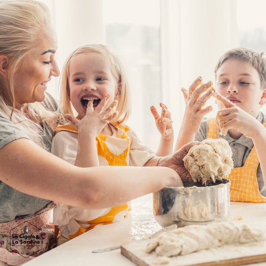 des enfants et leur maman cuisinent dans la joie et la bonne humeur